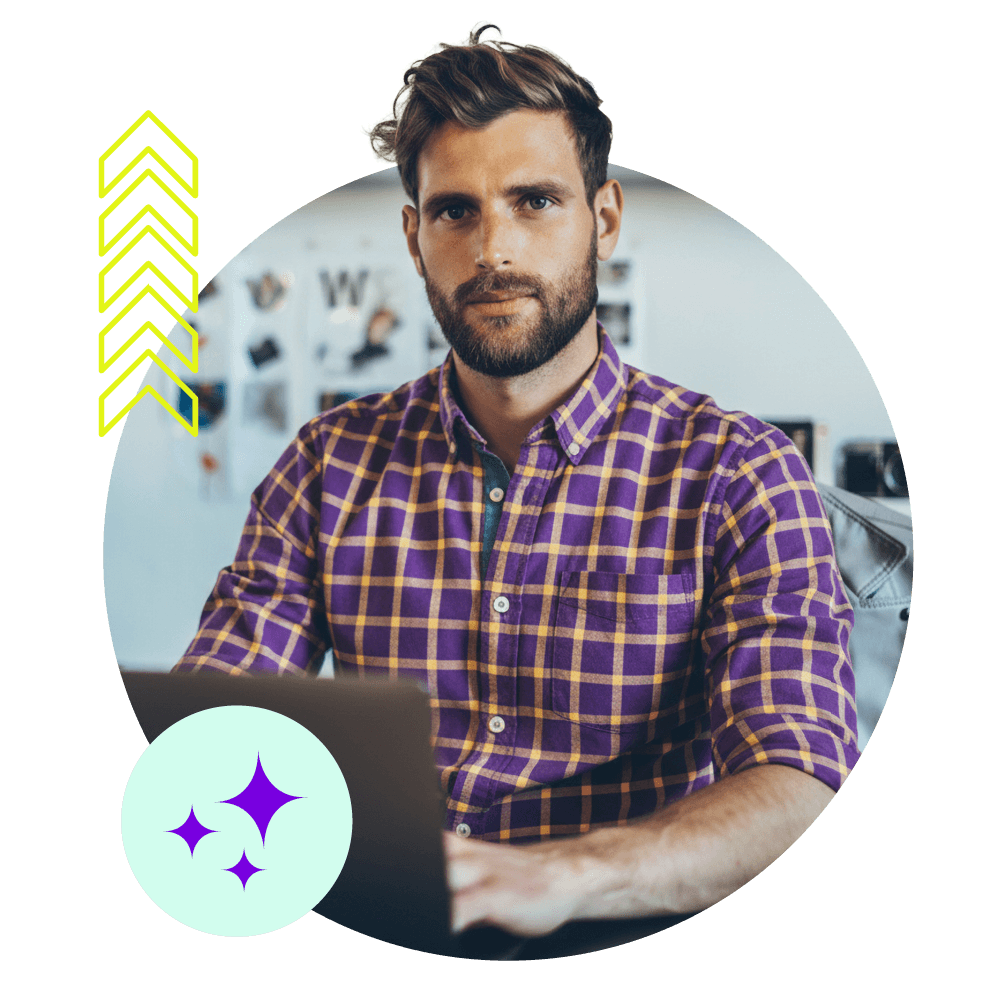 Ein Mann sitzt an seinem Notebook in einer kreativen Arbeitsumgebung