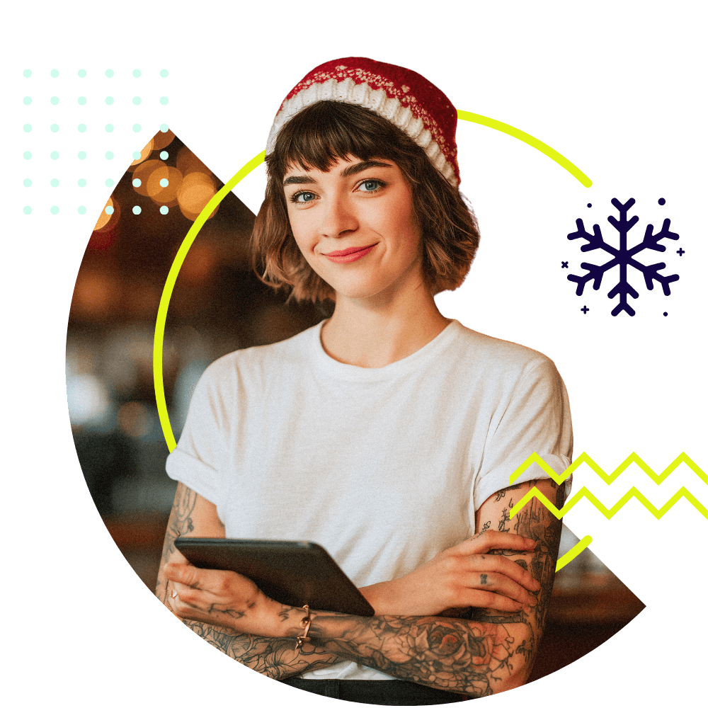 Frau mit Tablet und winterlicher Mütze schaut in die Kamera