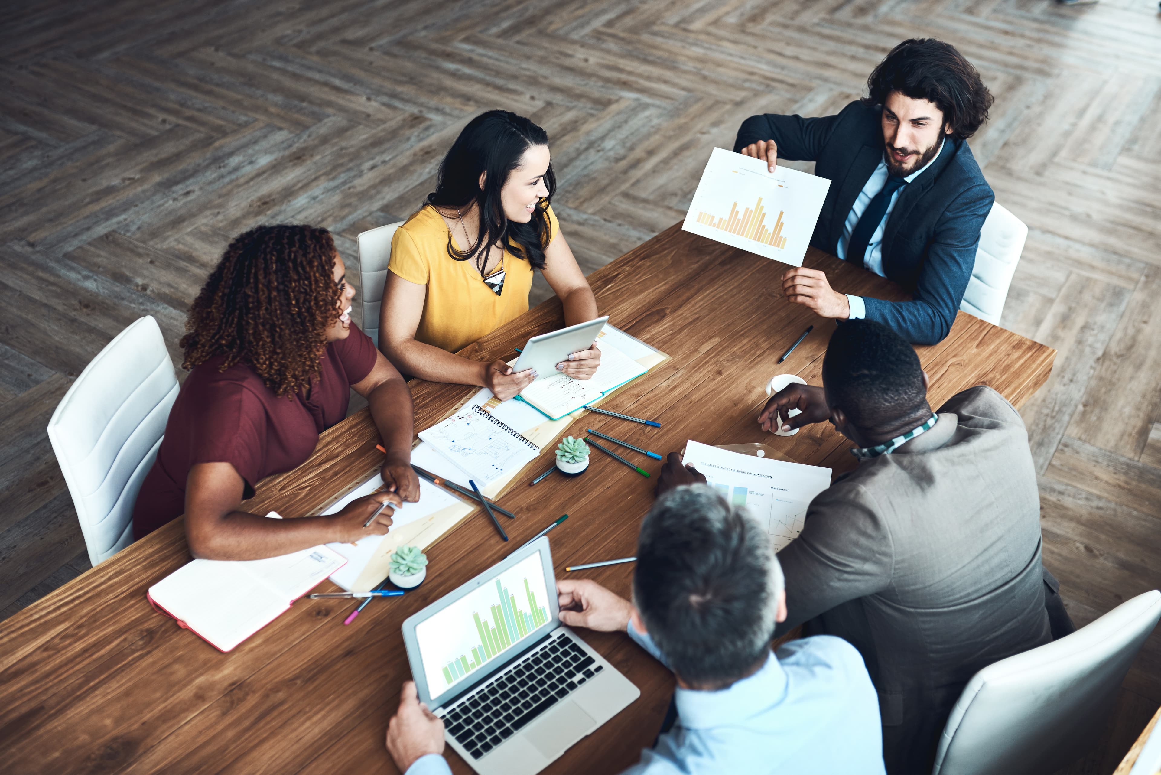 Marketing Team sitzt zusammen an einem Tisch und schauen über die Ergebnisse einer Performance Marketing Kampagne.